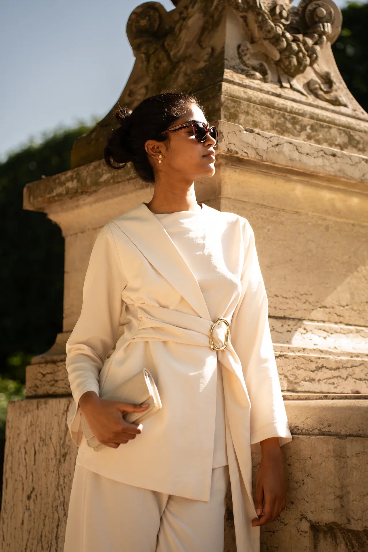 Veste blanche élégante avec boucle dorée et pochette de soirée