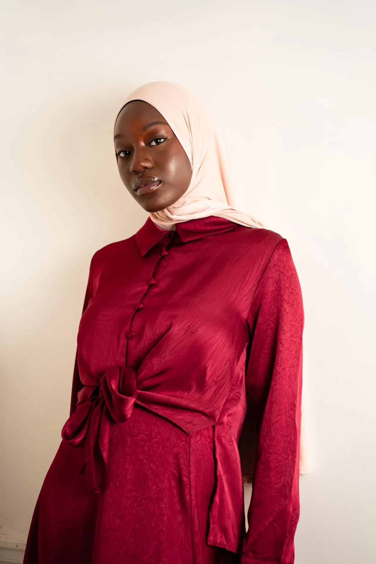 Robe longue satinée rouge bordeaux mastour avec nœud à la taille et hijab beige