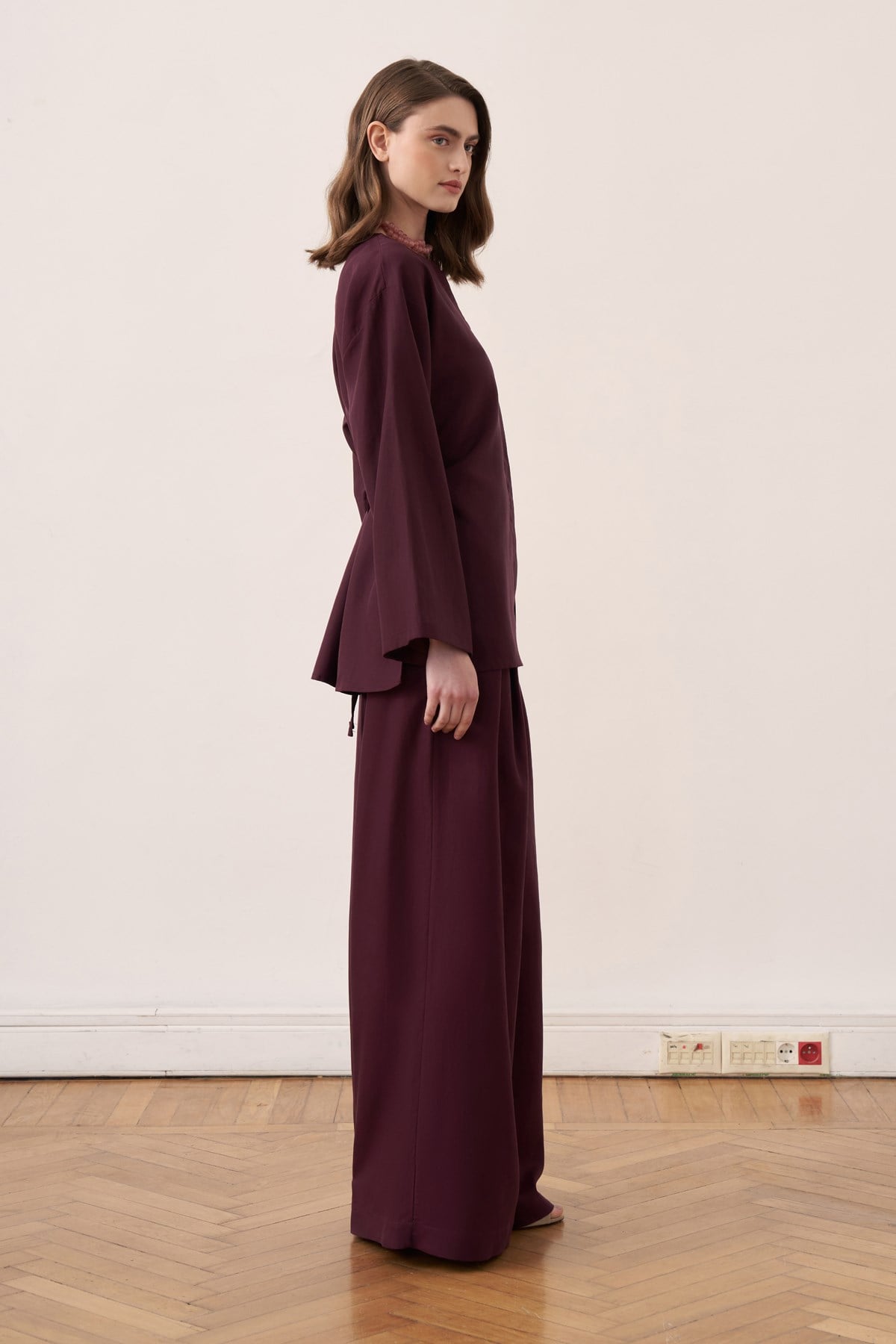 Vue de profil d'un ensemble tunique longue et pantalon amples violet prune