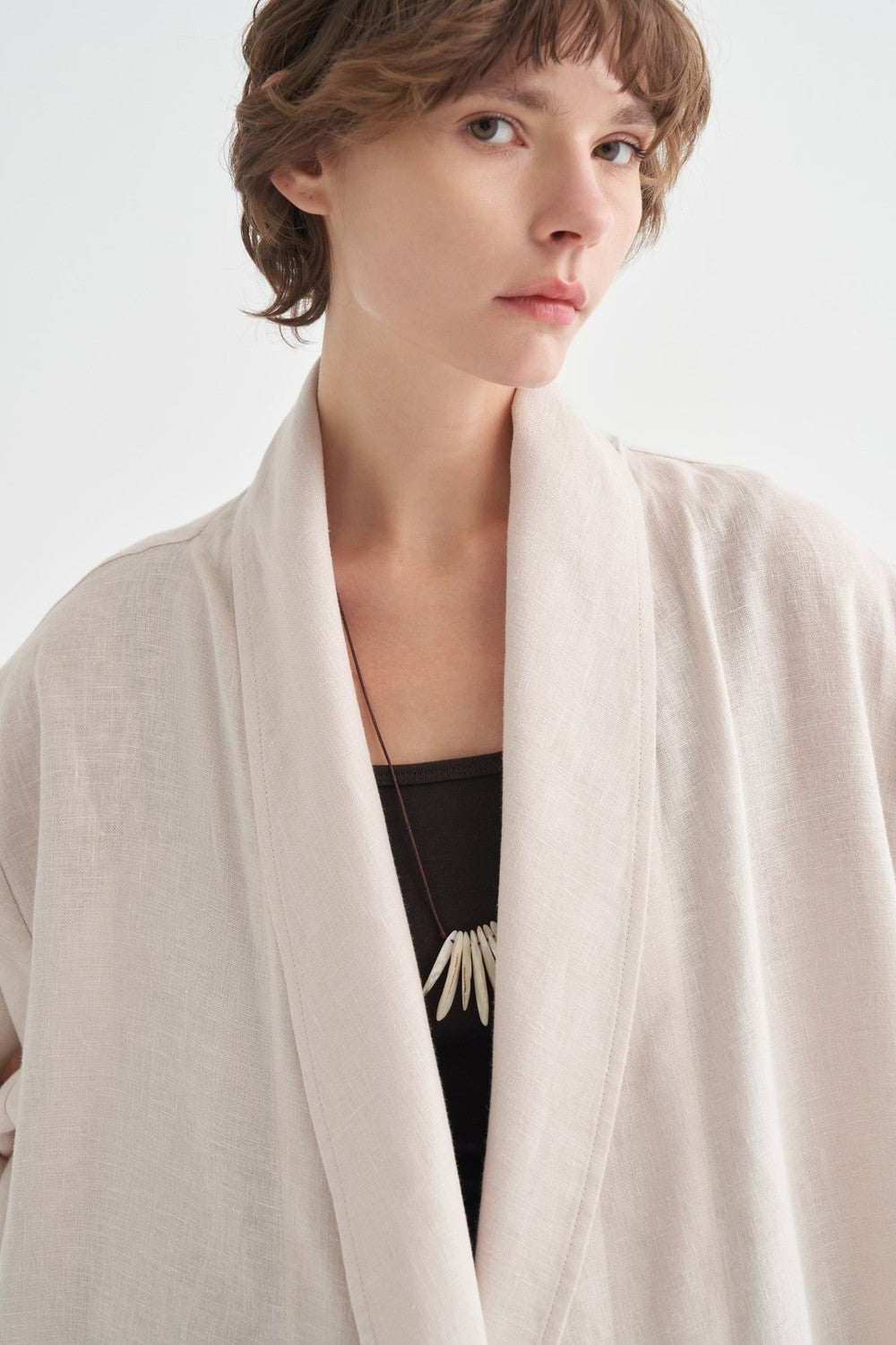 Gros plan sur le col châle et le tissu du kimono beige clair - ZAYÉRA Paris