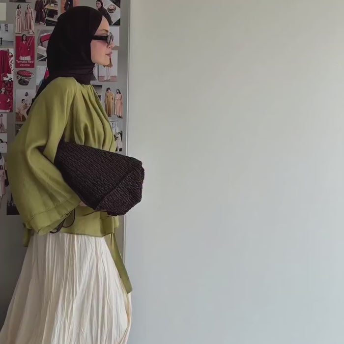 Vidéo montrant une tunique ceinturée vert olive avec jupe longue plissée beige et hijab noir