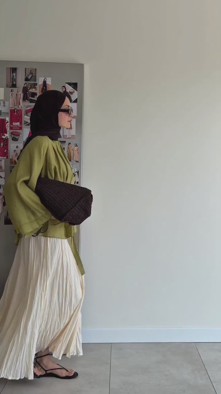 Vidéo montrant une tunique ceinturée vert olive avec jupe longue plissée beige et hijab noir