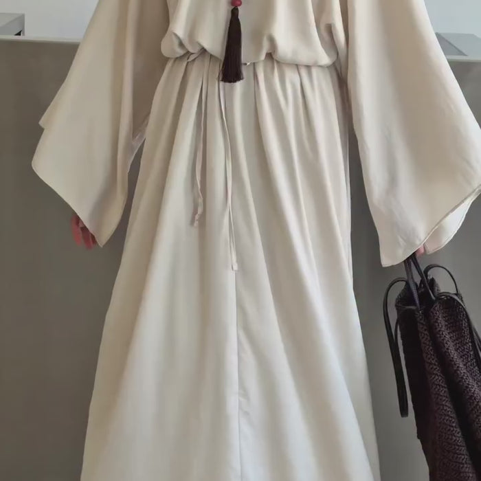 Vidéo montrant une robe longue ceinturée blanc cassé avec hijab noir