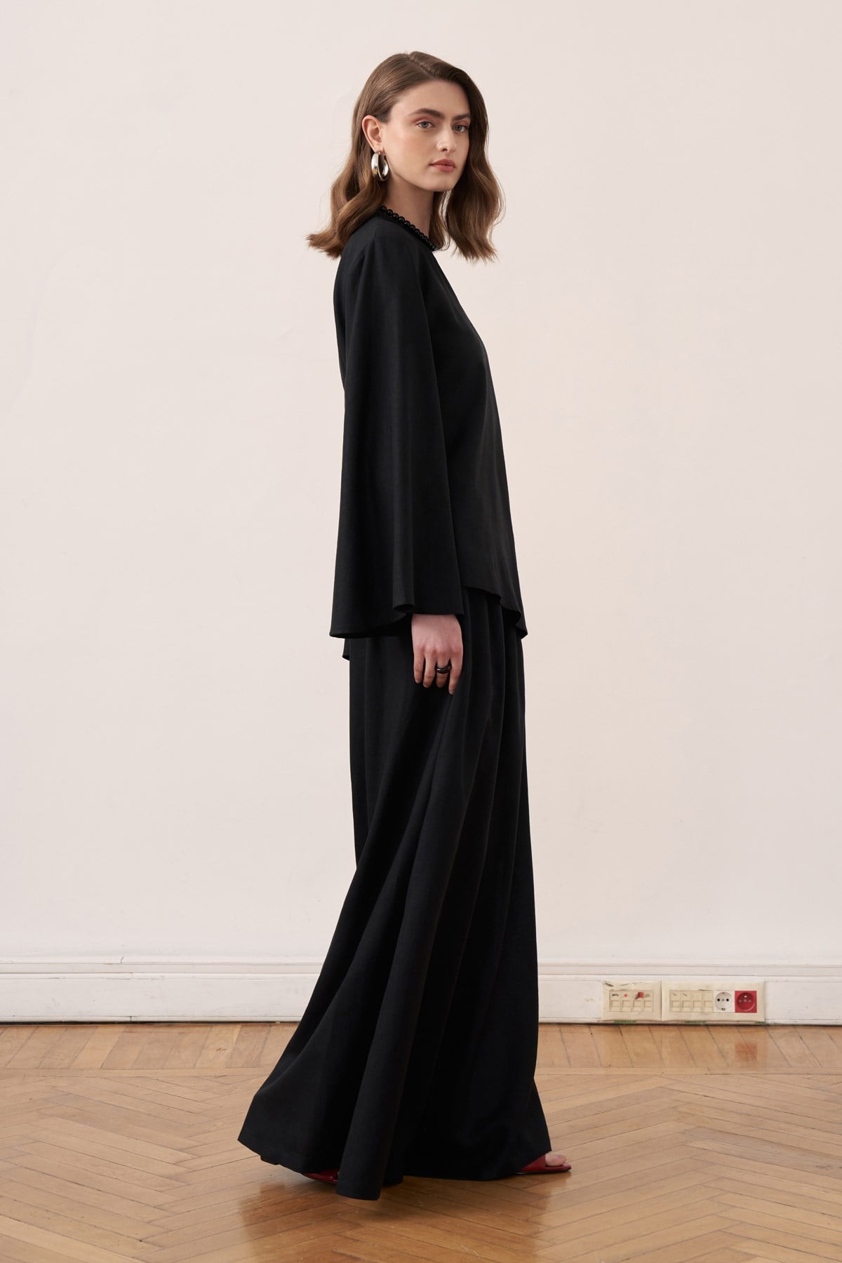 Vue de profil d'un ensemble tunique longue et pantalon amples noir